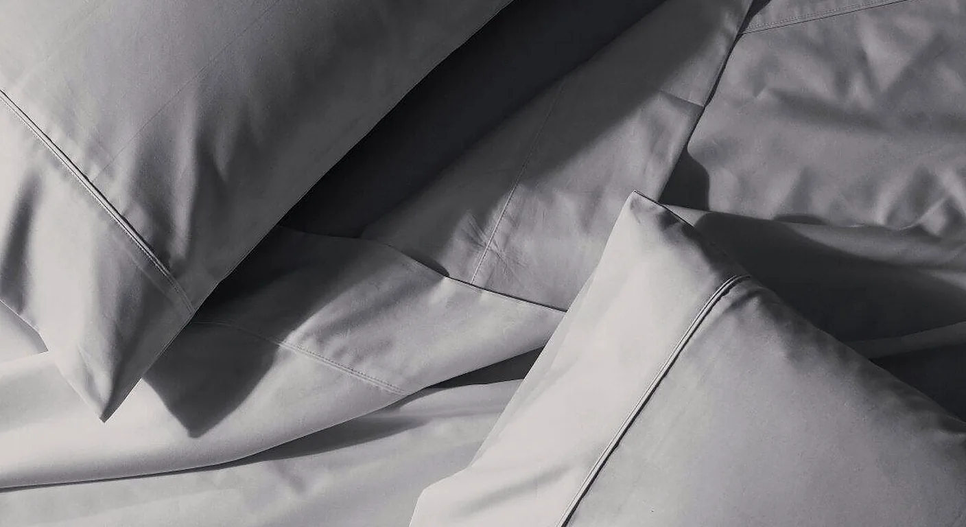 Close-up of grey cotton sheets and pillowcases